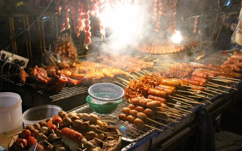 相关推荐封面占位：夜市摊位热气升腾，人群穿行其间，暖黄灯光与紫色霓虹交织